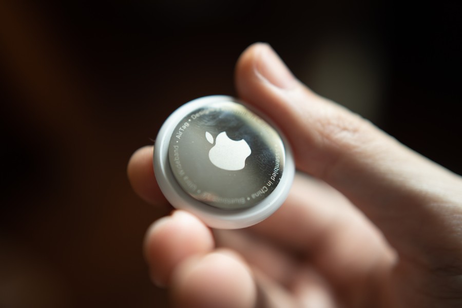 Χέρι κρατάει apple airtag αυτοκινήτου, σε μαύρο φόντο