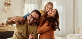 Ευτυχισμένη τριμελής οικογένεια στην κρεβατοκάμαρά τους