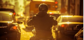 Οδηγός μηχανής σε μποτιλιάρισμα φωτισμένος από το ηλιοβασίλεμα