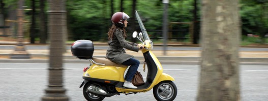 Οδηγός κίτρινης μηχανής σε οδό με δέντρα