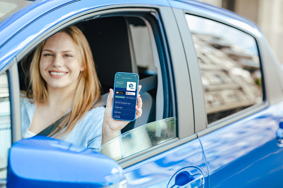 Χαμογελαστή οδηγός δείχνει την σελίδα του My Auto στο κινητό της
