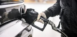 Άνθρωπος κρατά αντλία καυσίμων και γεμίζει ρεζερβουάρ αυτοκινήτου